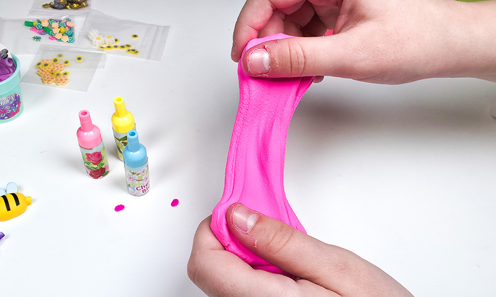 Child playing with bright pink butter slime from the So Slime Flower Mini Garden scented slime k