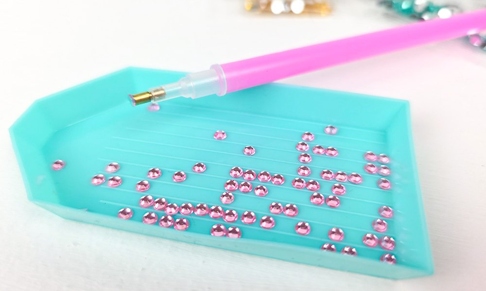 pink gems in tray with pen